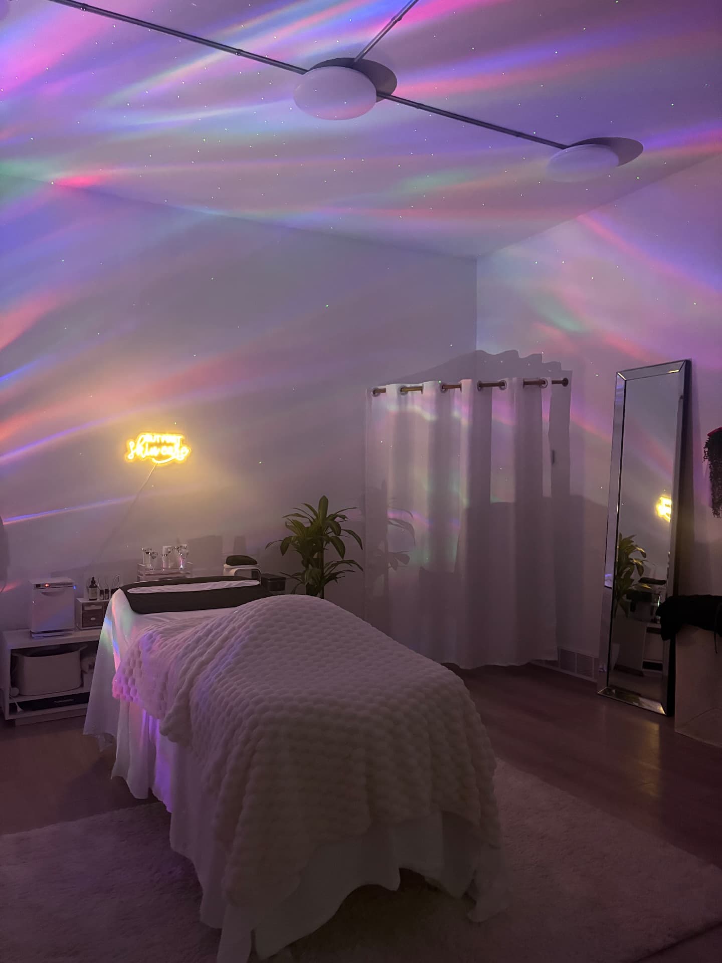 The Aurora Skin Co. treatment room glowing under the aurora projector